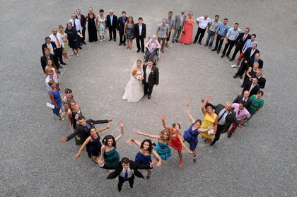 Hochzeitsgesellschaft formt ein Herz, von oben fotografiert