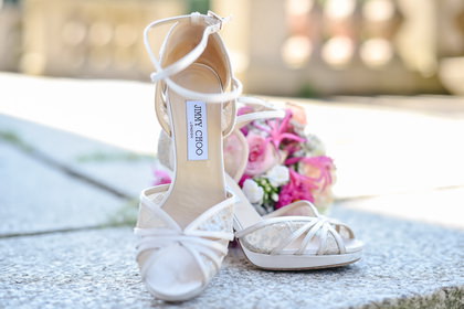 Elegante Brautschuhe und ein pinkfarbener Brautstrauß