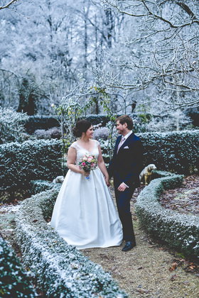 Winterhochzeit: Brautpaar im verschneiten Garten