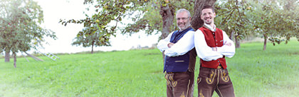 Bräutigam und Begleiter in Tracht auf einer Wiese