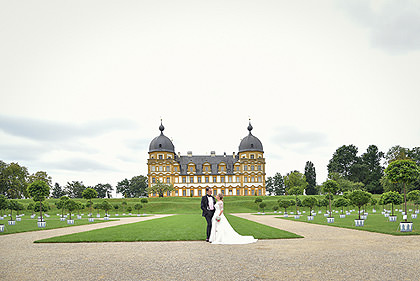 Brautpaar vor Schloss Seehof mit barockem Garten