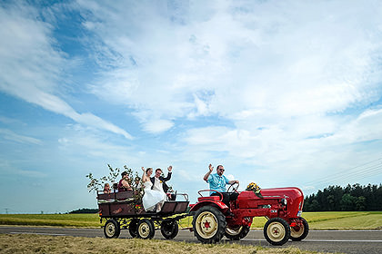 Hochzeitsgesellschaft feiert auf einem Traktor-Anhänger