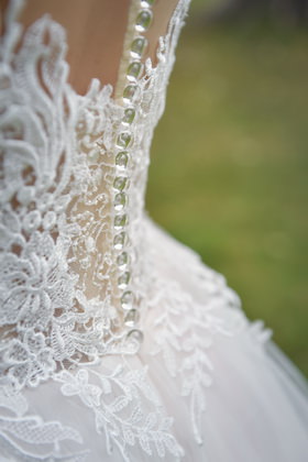 Detail des Brautkleids: Spitze mit Perlknöpfen