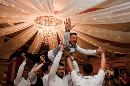 Feiernde Hochzeitsgesellschaft unter dem Kronleuchter