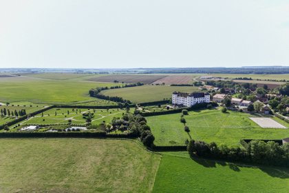 Luftaufnahme der Hochzeitslocation in grüner Landschaft